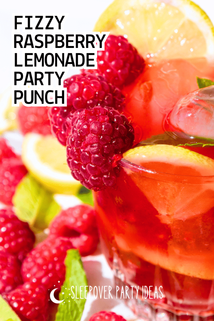 Fizzy Raspberry Lemonade Party Punch in a glass on a party table with raspberry drink garnish and lemon slices