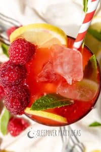 Sparkling part punch with lemonade and raspberries in a party drink glass with straw