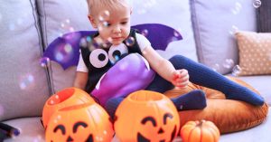 toddler in Halloween costume with pumpkins for Fun Toddler-Friendly Halloween Party Ideas