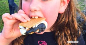 Outdoor Fall S'mores Party Ideas with party guest eating campfire smores - sleepoverpartyideas.com