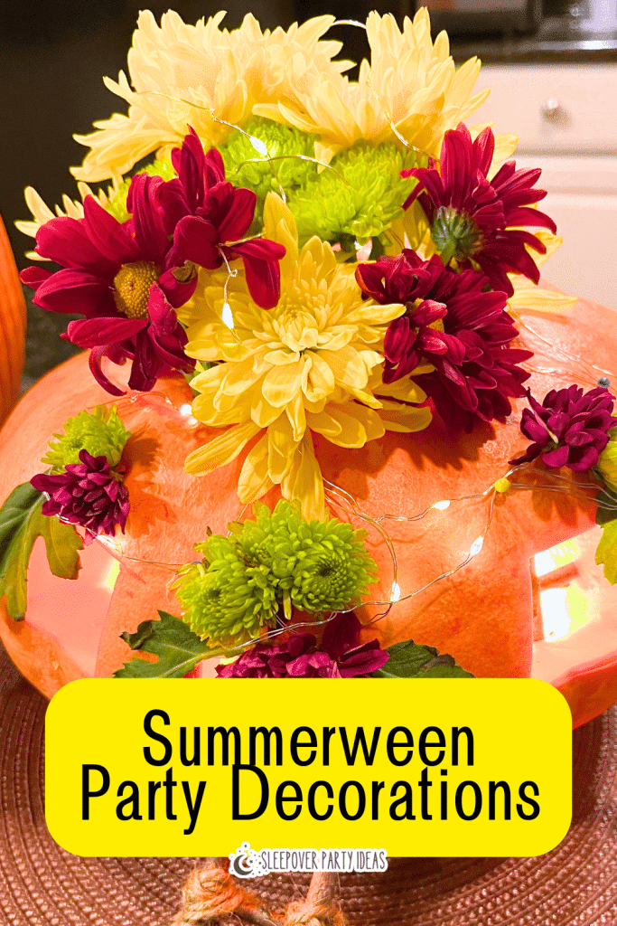 Summerween Party Decorations with Pumpkin Flowers pumpkin with flowers and lights on a Summerween party table decorations centerpiece with text on top