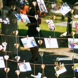 graduation party photo ideas with different grad pictures clipped on twine at an outdoor grad party